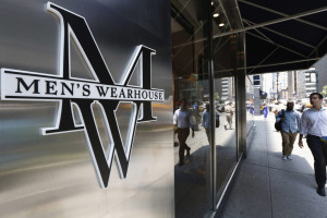 People pass by a Men's Wearhouse store in New York June 25, 2013. Men's Wearhouse Inc said it fired founder and Executive Chairman George Zimmer after he pushed to take the company private and effectively demanded to be reinstated as the sole decision maker at the clothing chain. REUTERS/Brendan McDermid (UNITED STATES - Tags: BUSINESS TEXTILE LOGO)