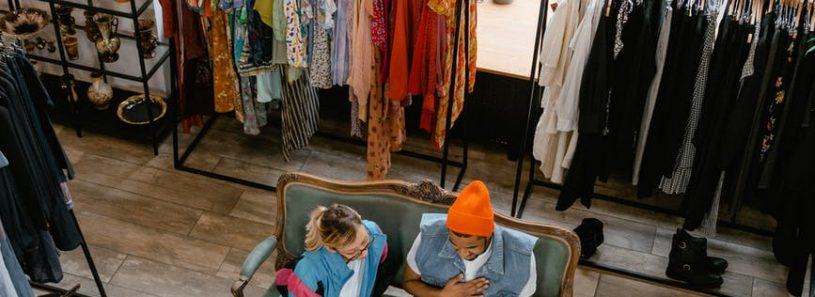 a man and woman sitting on the couch inside the boutique while having conversation